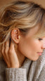 Woman model posing she wearing CZ labret flat back stud piercing earrings in gold color. Cartilage, lobe studs, tragus piercing