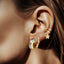 Woman ear with gold chunky hoop earrings, small gold hoop and double ear cuff with cz star charm