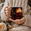 Midnight Love Rhythms mug held in hands with roses and cozy candlelight
