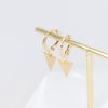Gold-plated hoop earrings with triangle charm hanging on a stand in a golden color. The hoop earrings feature a sleek, minimalist design with a delicate triangle charm that adds a touch of sophistication and style. The gold plating gives the earrings a luxurious and elegant look, and the stand provides a modern and stylish display for showcasing the earrings."